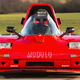 A photo of the front of a red Modulo three-wheeled car.